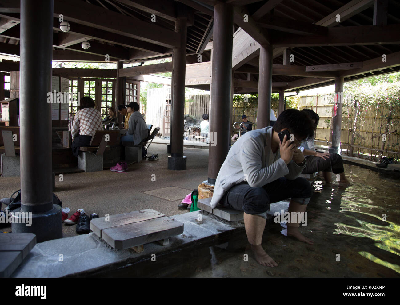 I turisti giapponesi usando un bagno termale pubblico piede bagno Foto Stock