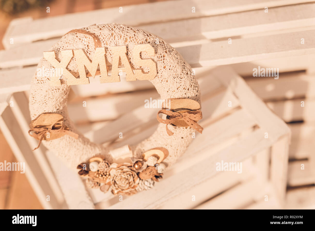 Casa natale decorazione con luci di masterizzazione su bianco sullo sfondo di legno. Ghirlanda di Natale, moody sfondo stagionali Foto Stock