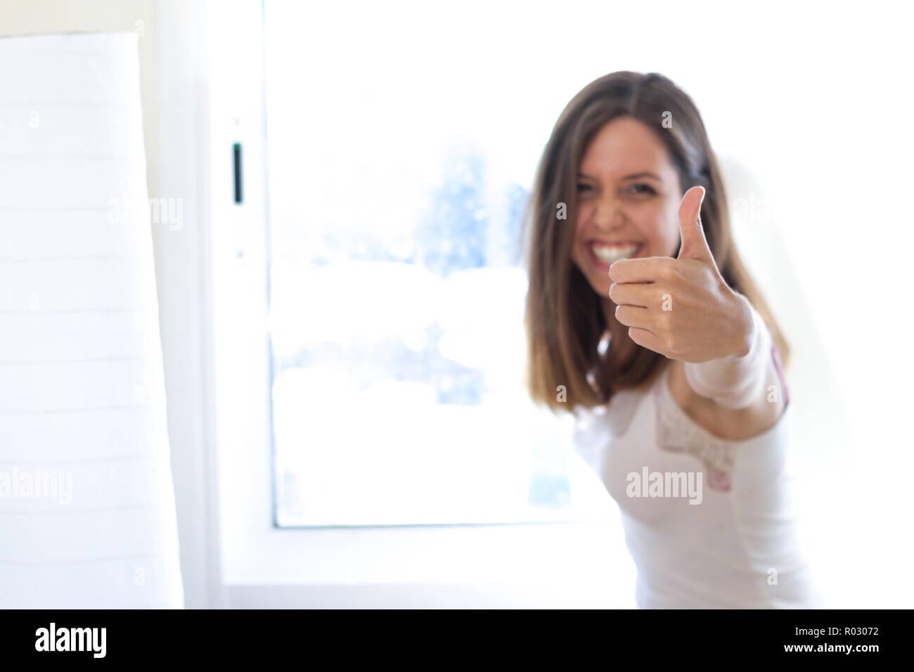 Perfect Smile Brunette capelli corti donna con positivo e allegro atteggiamento mostrando il suo dito verso l'alto, pollice in alto, con gesto di approvazione. Emozioni umane. Foto Stock