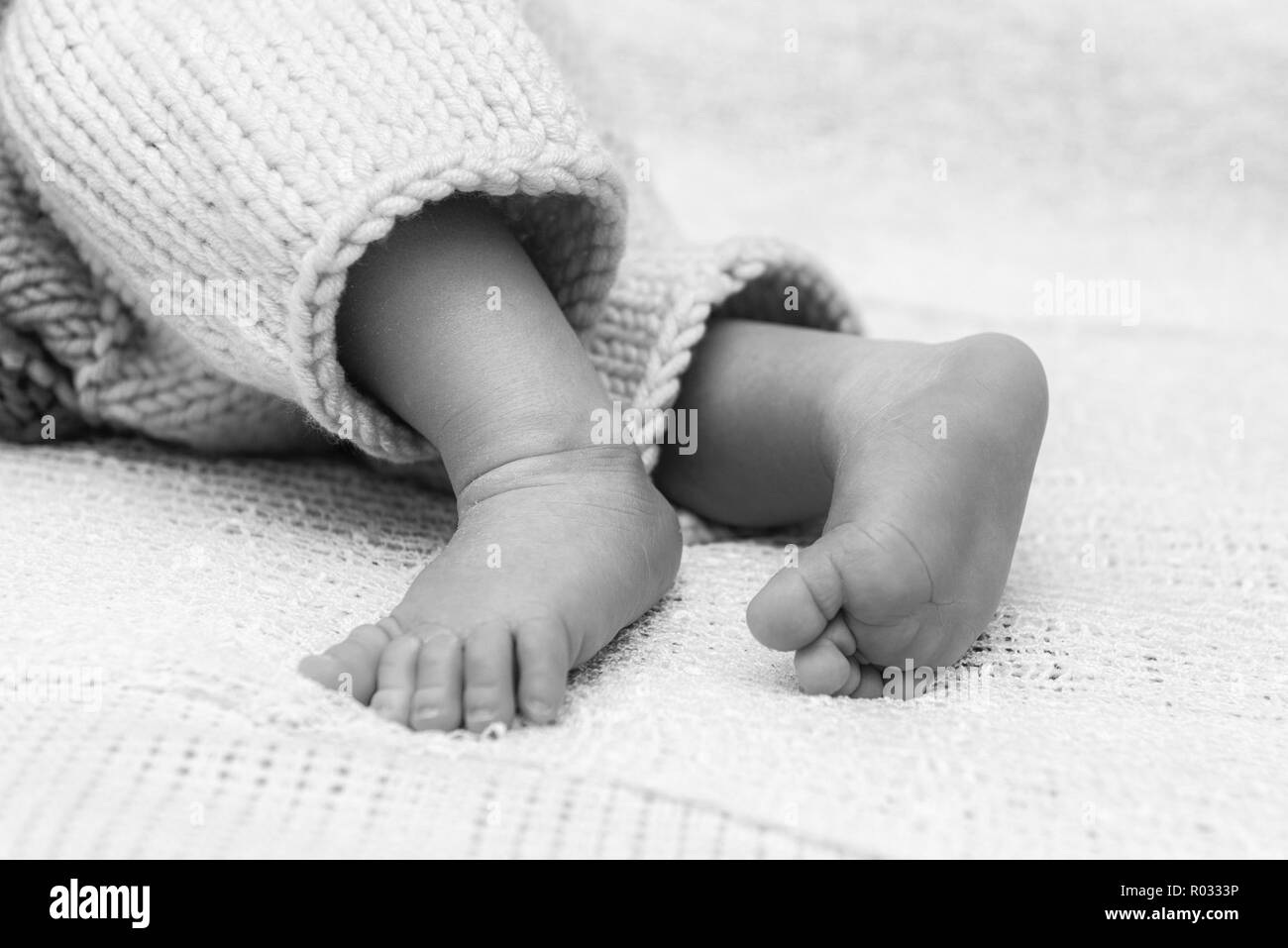 Primo piano di un neonato piedi con belle messa a fuoco selettiva. Concetto di congedo di maternità e tenerezza Foto Stock
