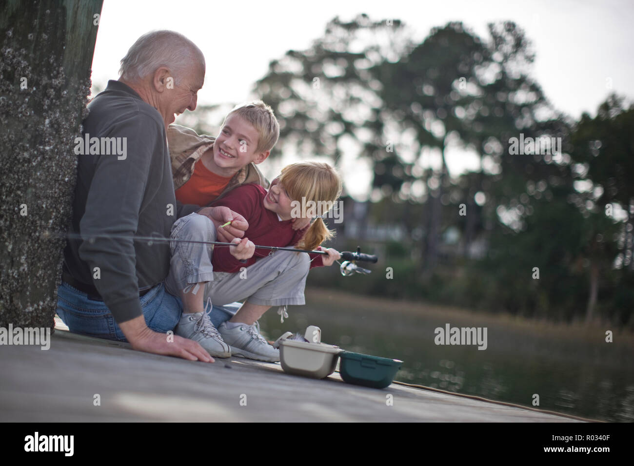Nonno e nipoti di pesca sul molo Foto Stock