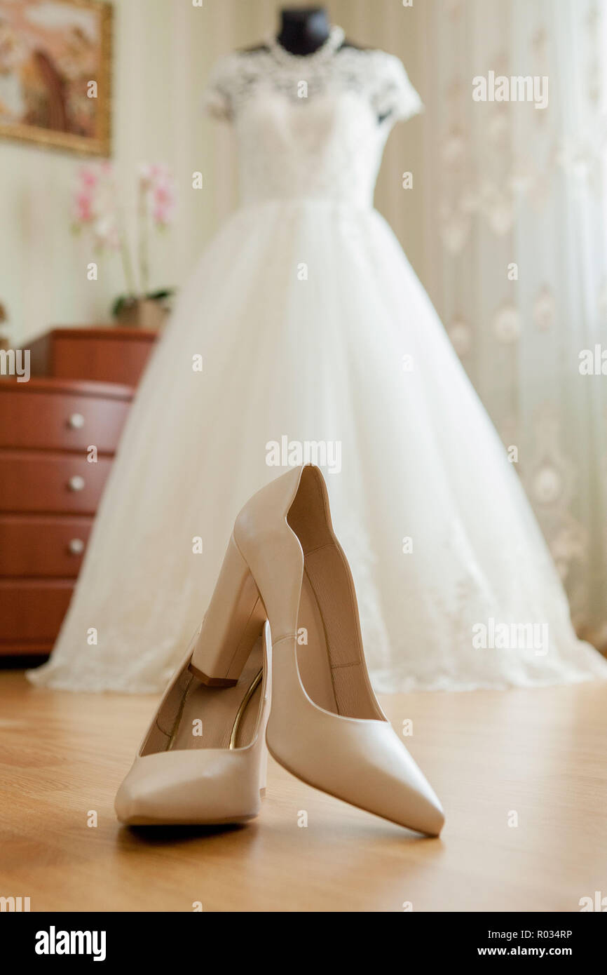 Scarpe matrimonio accanto alla parete gialla in appartamento Foto Stock