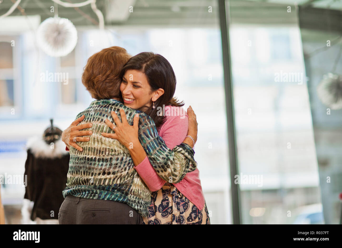 Sorridente metà donna adulta abbracciando la madre. Foto Stock