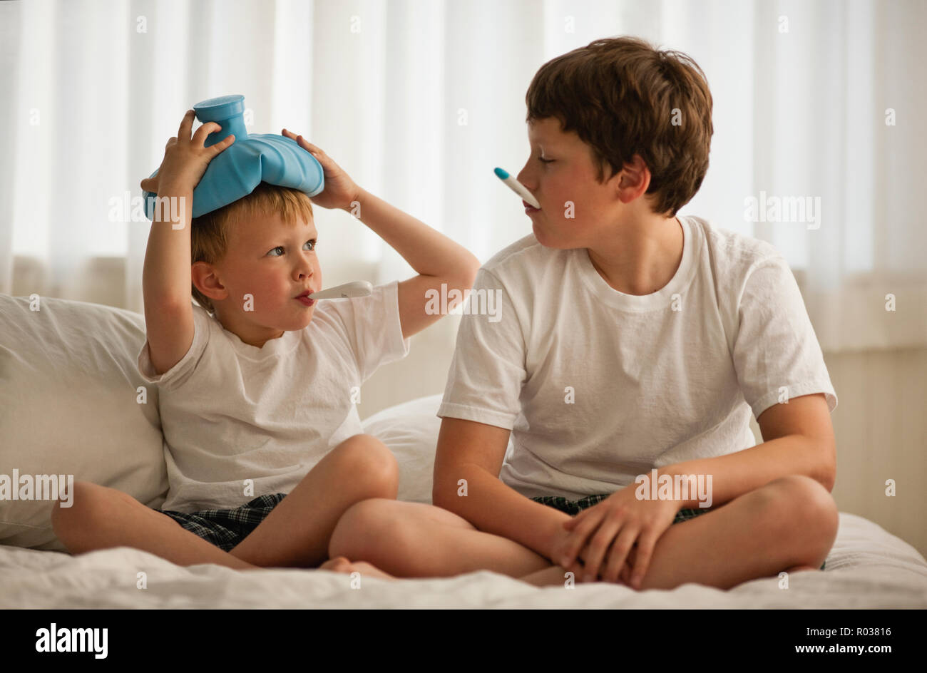 Due fratelli entrambi i malati con la febbre. Foto Stock