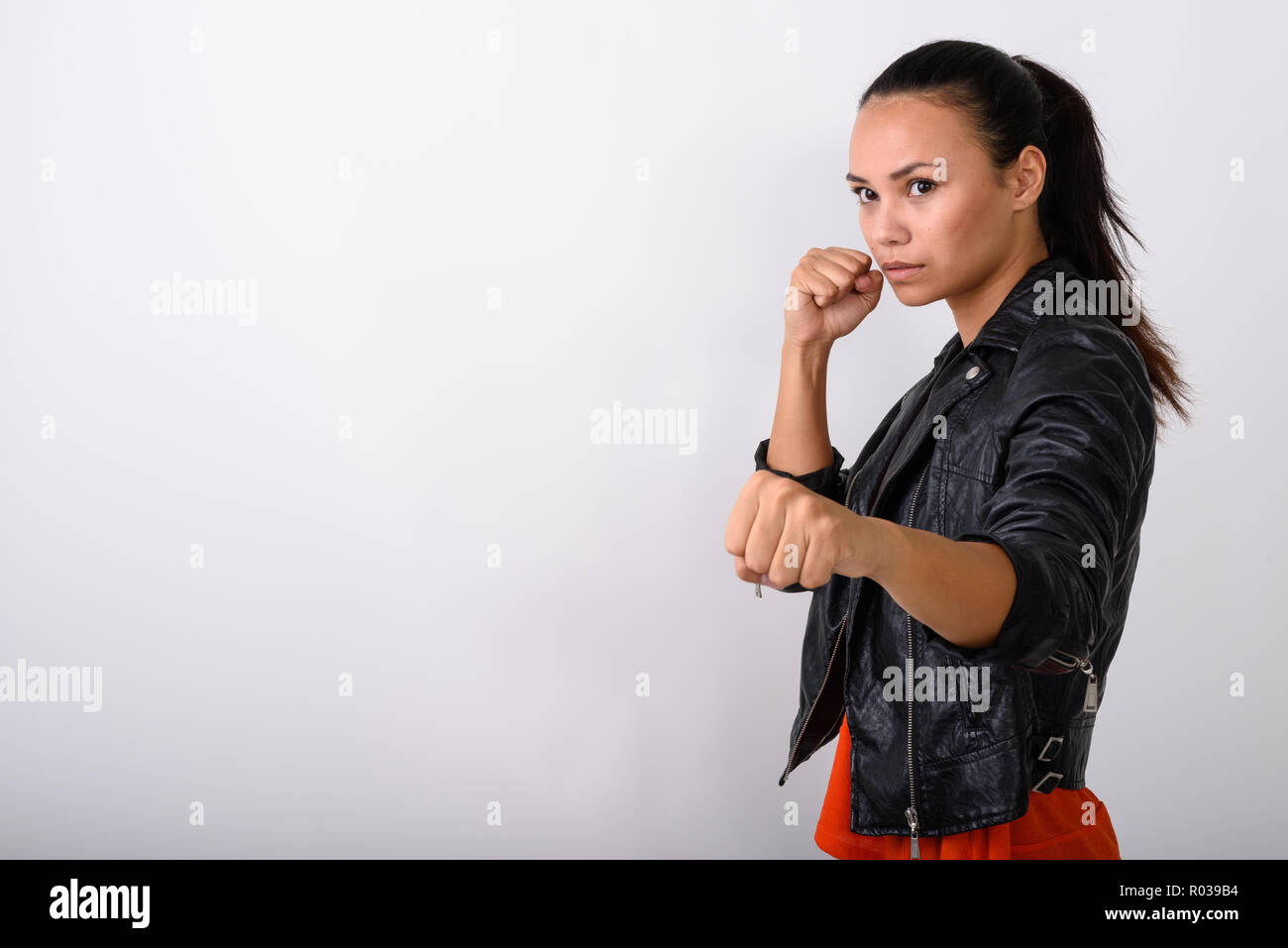 Studio shot della giovane donna asiatica guardando al lato con entrambe f Foto Stock