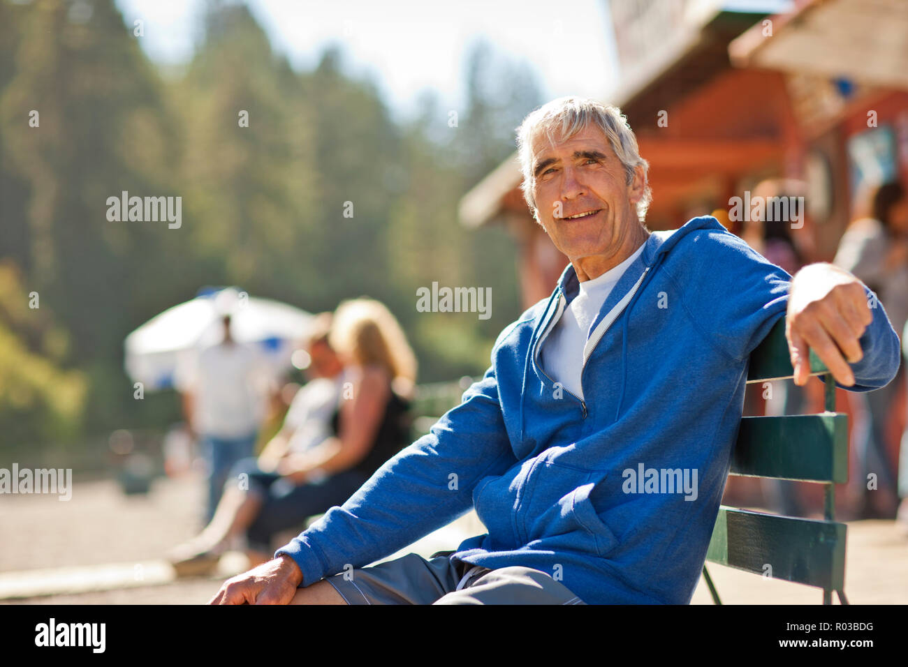 Ritratto di un felice senior uomo seduto su una panchina nel parco. Foto Stock
