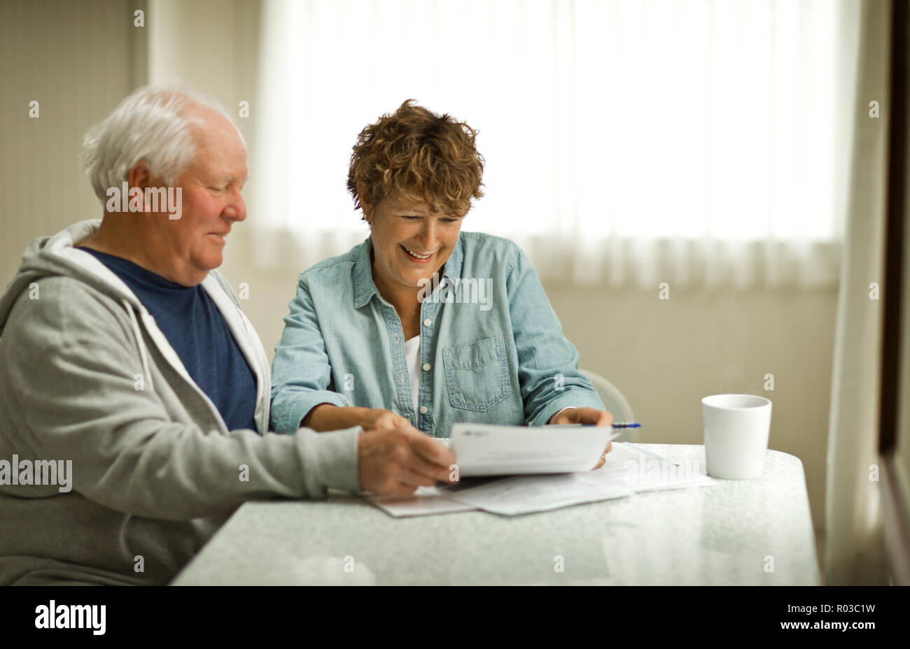 Coppia senior guardando oltre i documenti importanti. Foto Stock