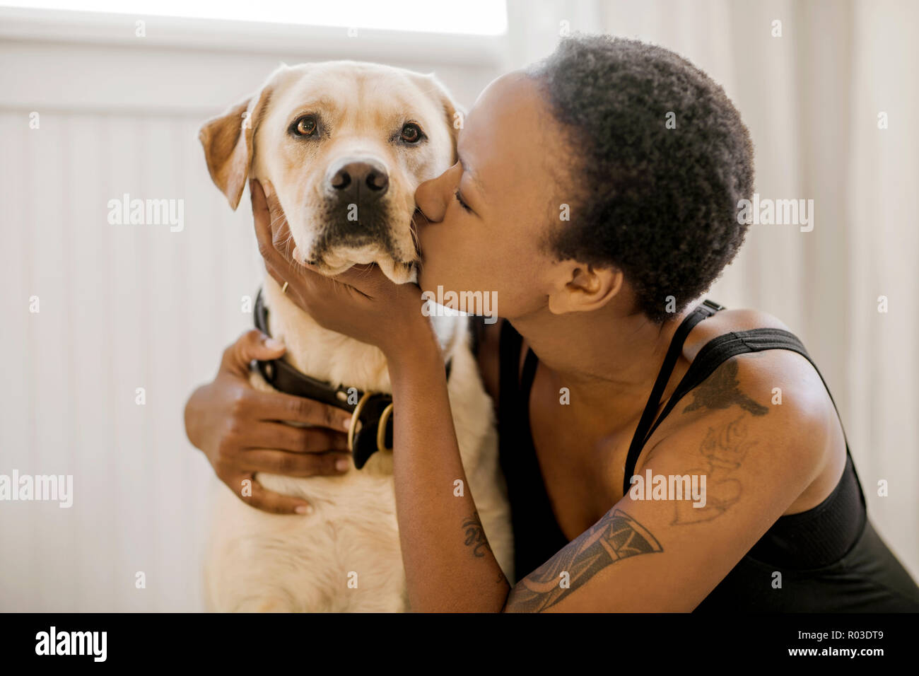 Felice giovane donna baciare il suo cane. Foto Stock