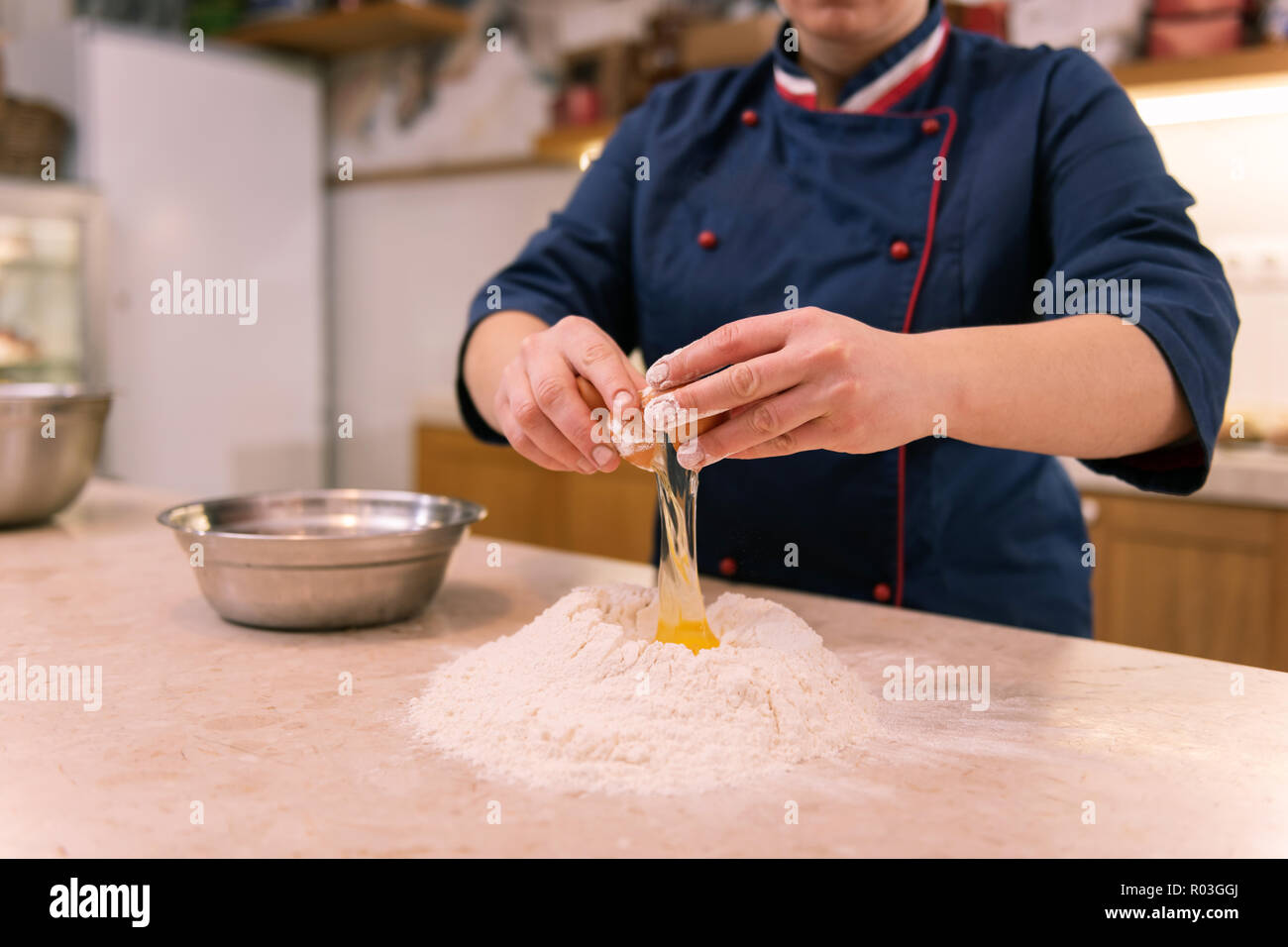 Chef in panetteria francese la rottura delle uova rendendo la pasta per croissant Foto Stock
