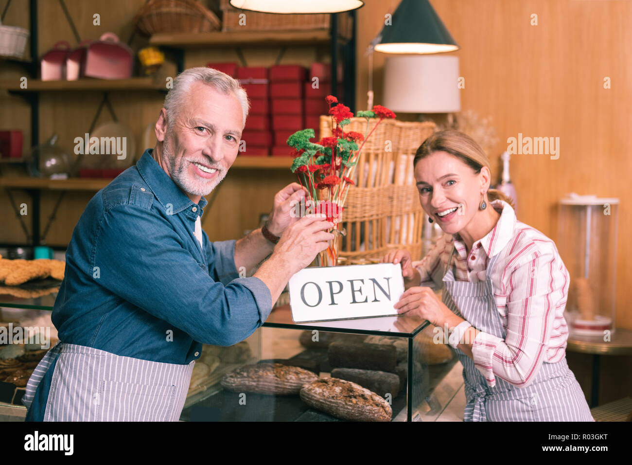 Coppia di esperti imprenditori salutare gli ospiti nella loro nuova caffetteria Foto Stock