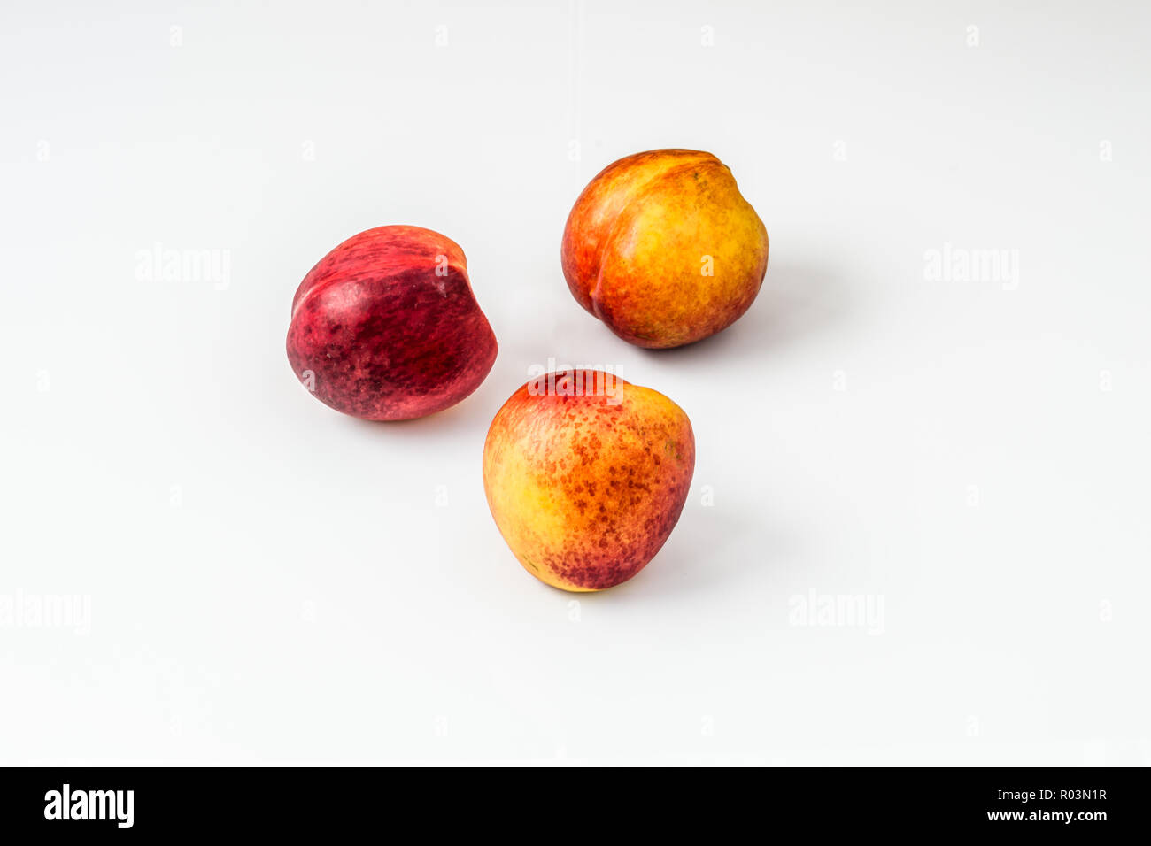 Mature le pesche noci isolati su sfondo bianco. Foto Stock