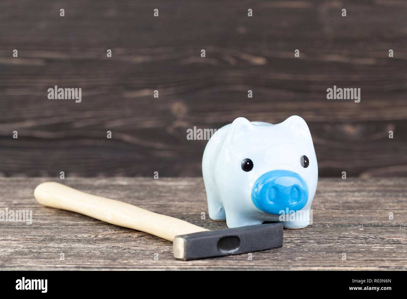Un blu salvadanaio per le monete in cui si aggiunge fino e salva i suoi risparmi, un suino a forma di salvadanaio con un martello per controllare la quantità di risparmi Foto Stock