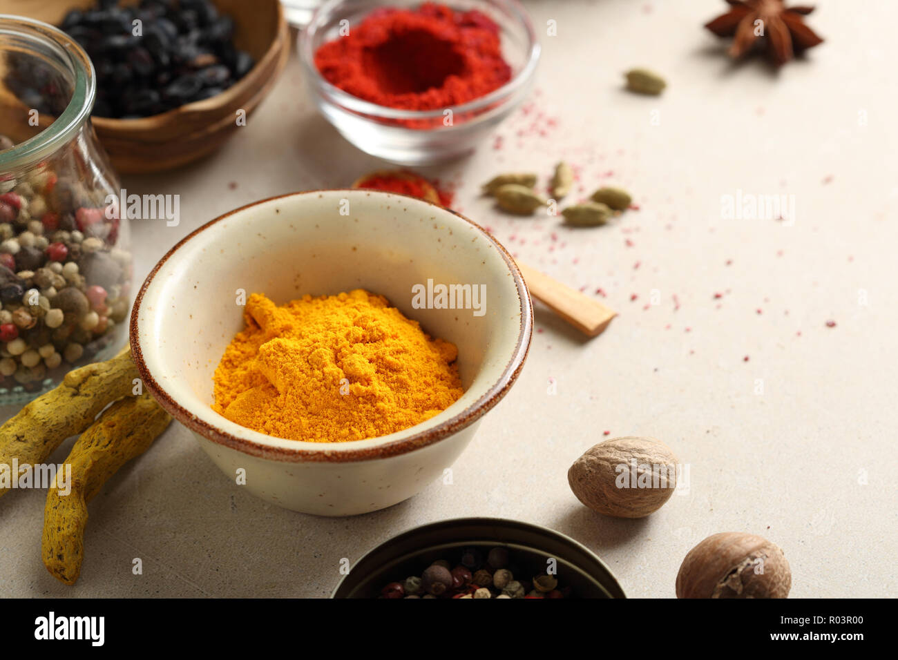 Curry in polvere in un recipiente e altre spezie Foto Stock