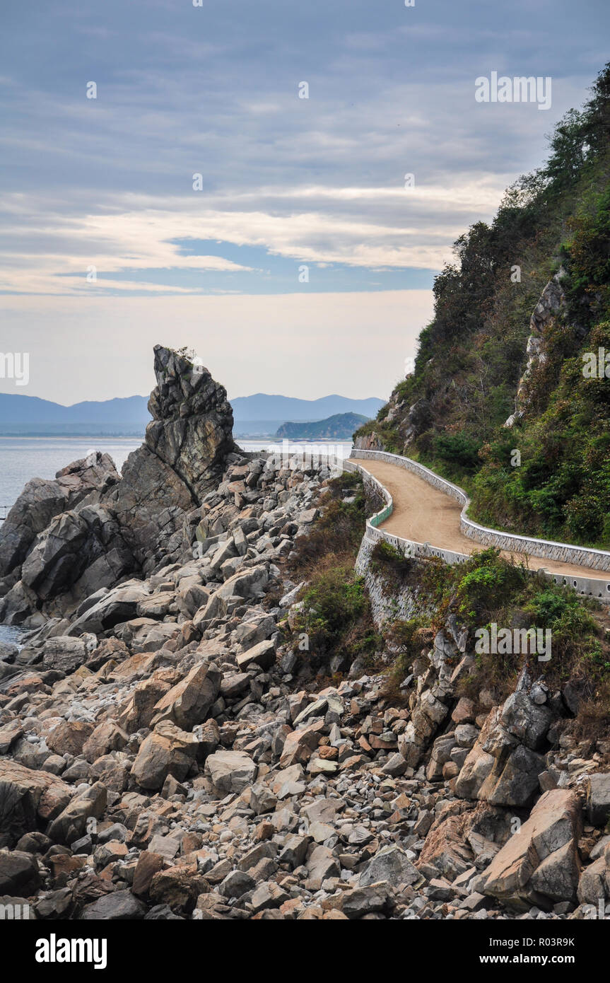 Lonely strada costiera conduce lungo il giapponese del mare e della spiaggia nel nord della Corea del Nord Foto Stock