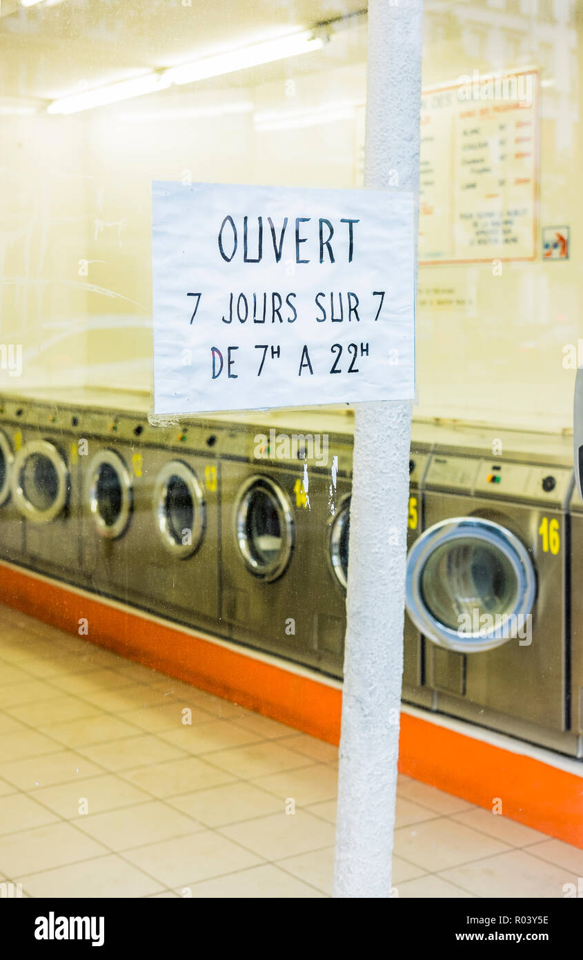 Vista esterna di Parigi lavanderia a gettoni, segno legge: "ouvert 7 jours sur 7 de 7 a 22 h aperto sette giorni a settimana" Foto Stock