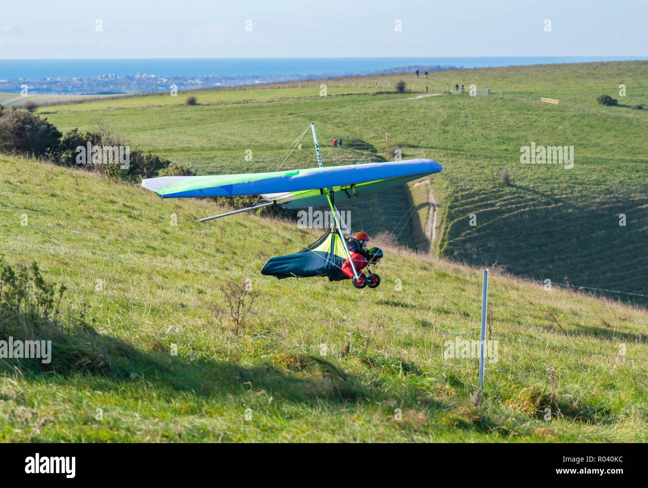 Tandem volare basso in un deltaplano, sta per sbarcare su South Downs in East Sussex, Inghilterra, Regno Unito. Foto Stock