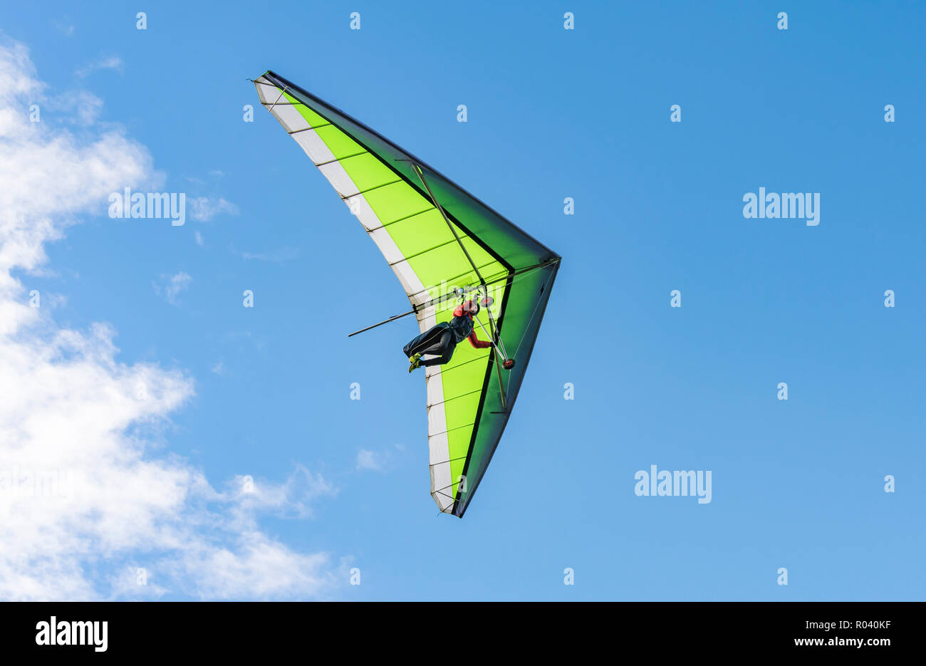 Uomo in deltaplano in autunno con cielo blu al South Downs in East Sussex, Inghilterra, Regno Unito. Foto Stock