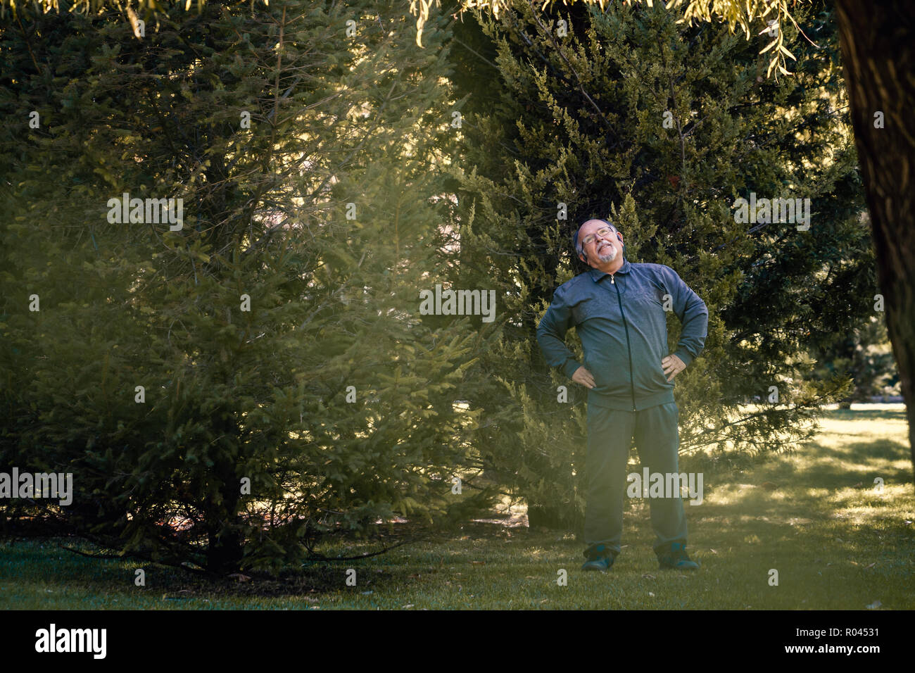 Senior uomo fare esercizio fisico in un parco verde Foto Stock