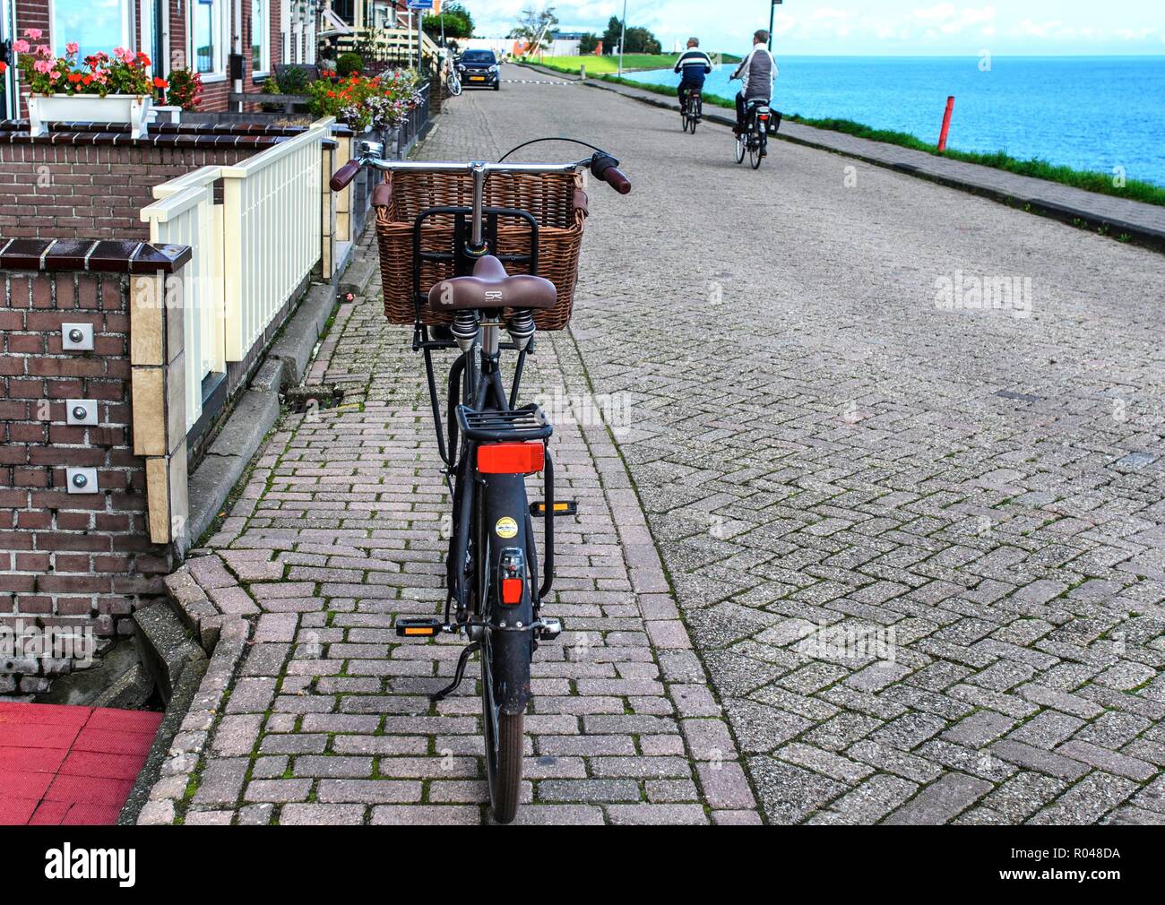 In bicicletta sulla strada del villaggio olandese. Foto Stock