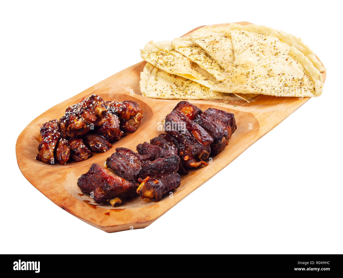 La birra snack sul piatto di legno. Grigliate di costolette di maiale e ali di pollo italiana con pane pita chips Foto Stock