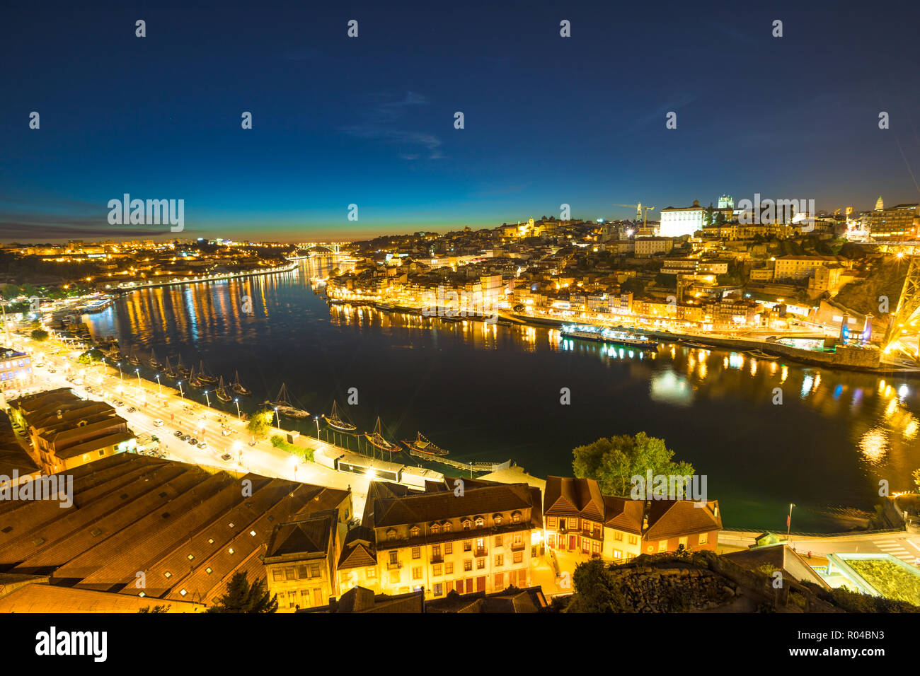 Rabelo e imbarcazioni turistiche sul fiume Douro. Porto vivace vita notturna del porto e dello skyline di Ribeira Waterfront da Dom Luis I Bridge di notte. Il pittoresco paesaggio urbano di Porto in Portogallo. Foto Stock