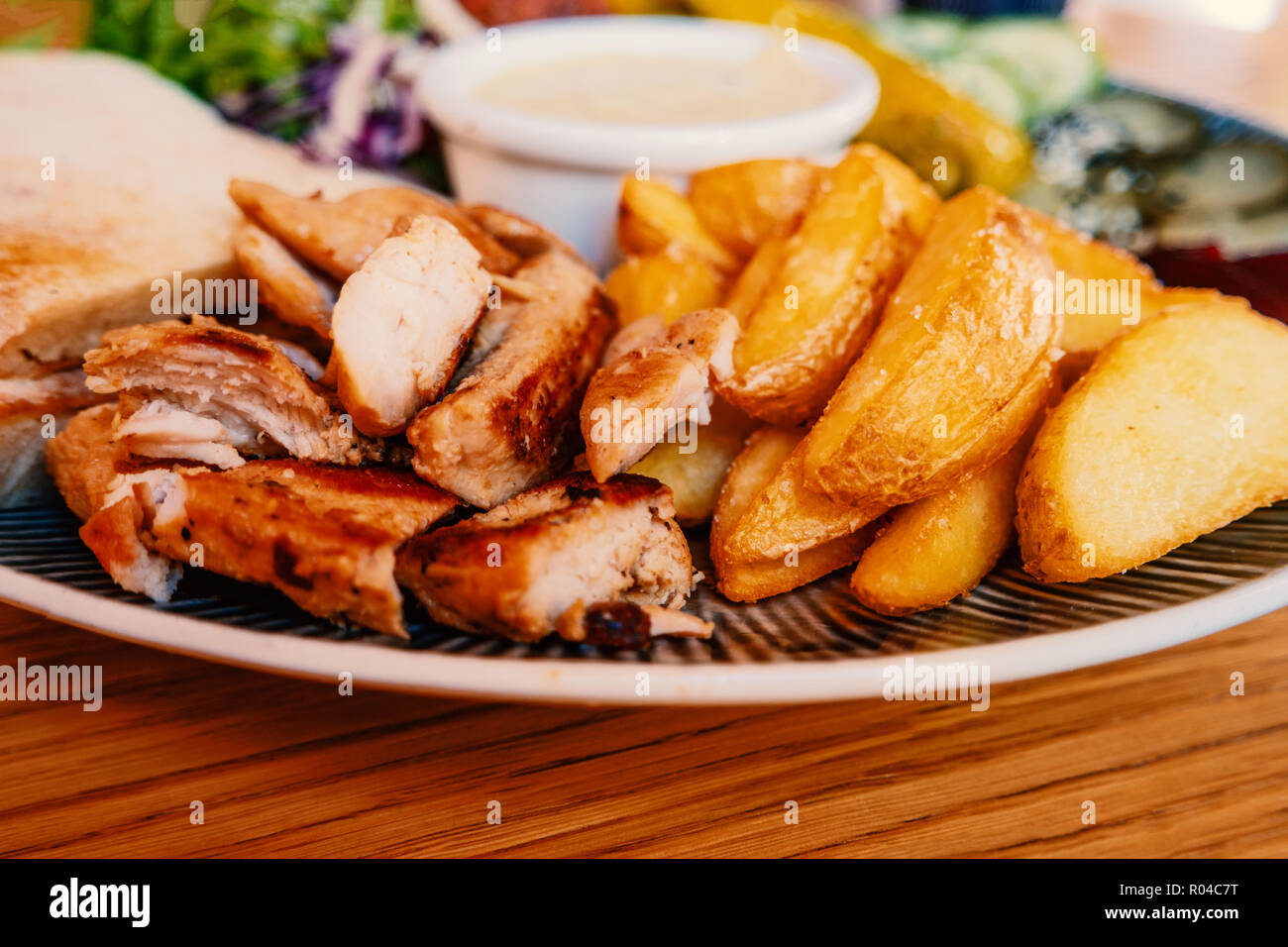 Piatto con grigliate di carne di pollo e patate fryed sulla tavola in arabo cafe Foto Stock