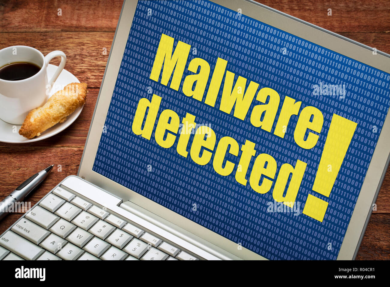 Rilevato malware alert su uno schermo di computer portatile con una tazza di tè Foto Stock