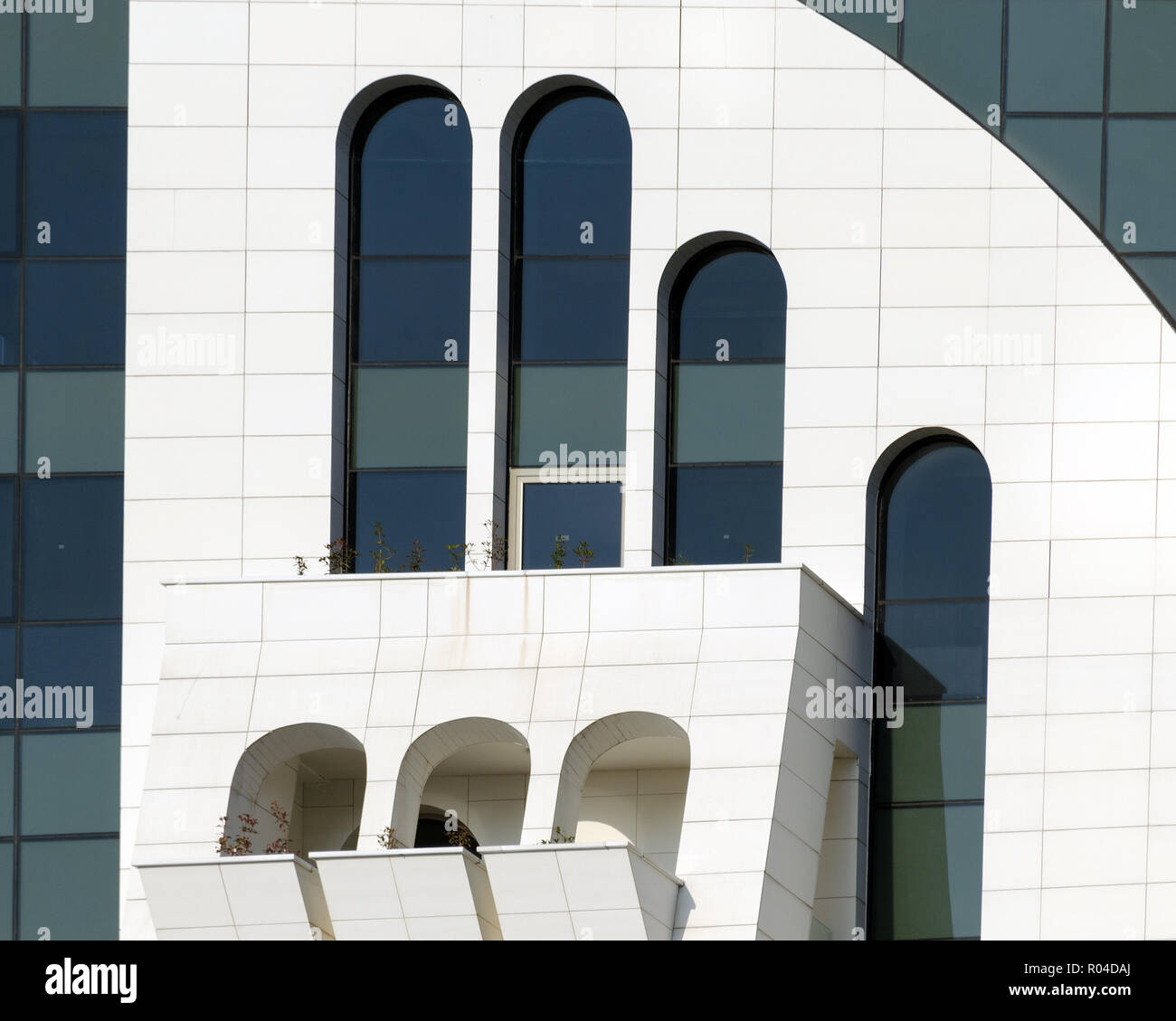 Particolare della facciata di edificio moderno - vista frontale in corrispondenza di finestre ad arco di diverse forme e dimensioni. Batumi, Georgia. Foto Stock