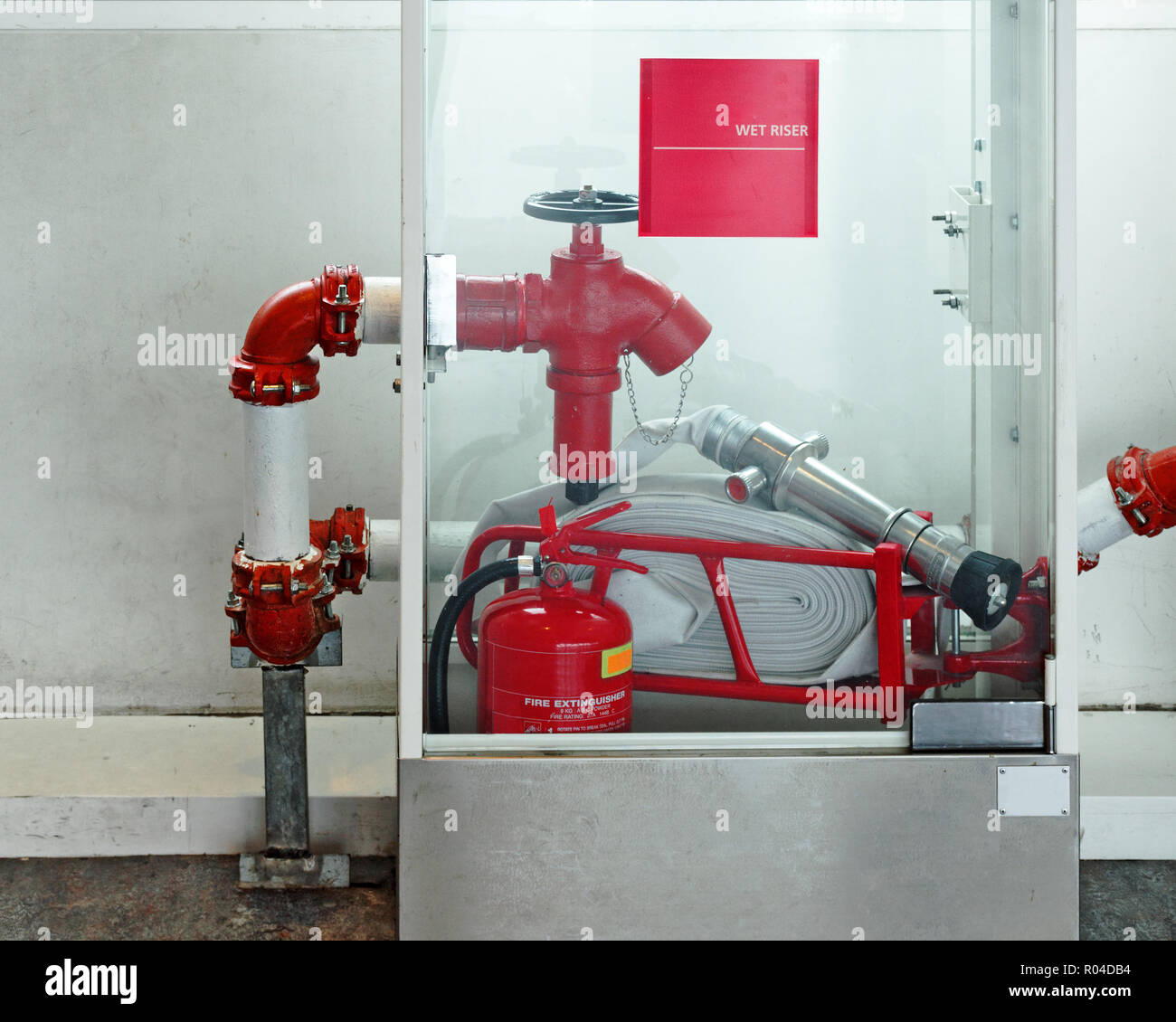 Sicurezza in caso di emergenza - kit idrante, valvola di alimentazione dell'acqua, estintore in una scatola di vetro. La sicurezza interna. Foto Stock