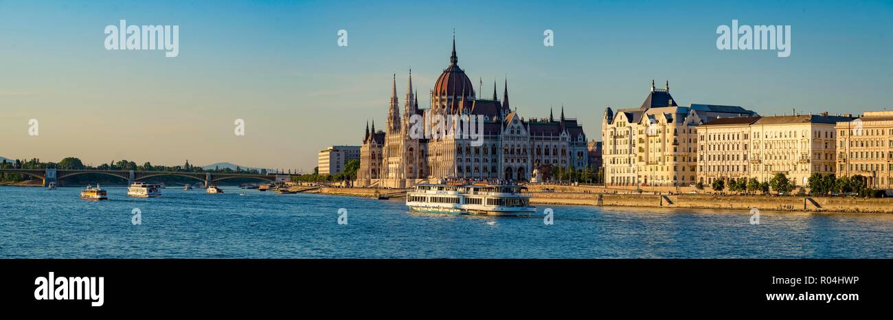 Ungheria, Budapest. La vista sul fiume Danubio verso il possente edificio del parlamento nella luce calda del tardo pomeriggio è in sospeso Foto Stock