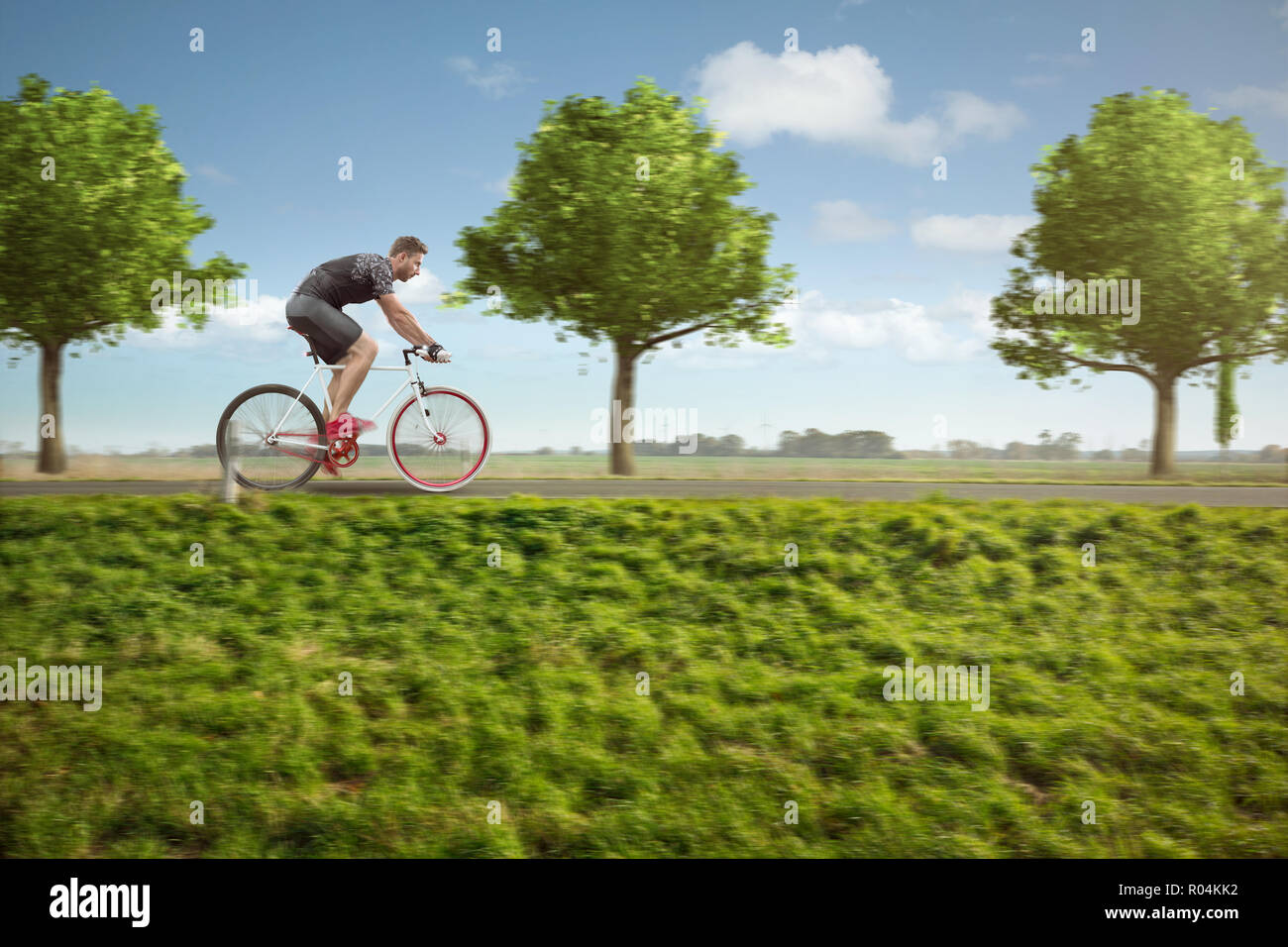 Ciclista su un paese verde road Foto Stock