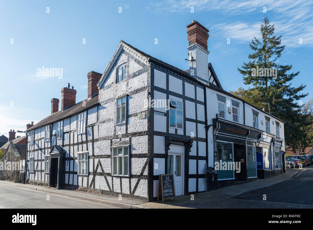 Grande nero e bianco edificio con travi di legno con finti mattoni dipinto nella parete Church Stretton, Shropshire Foto Stock