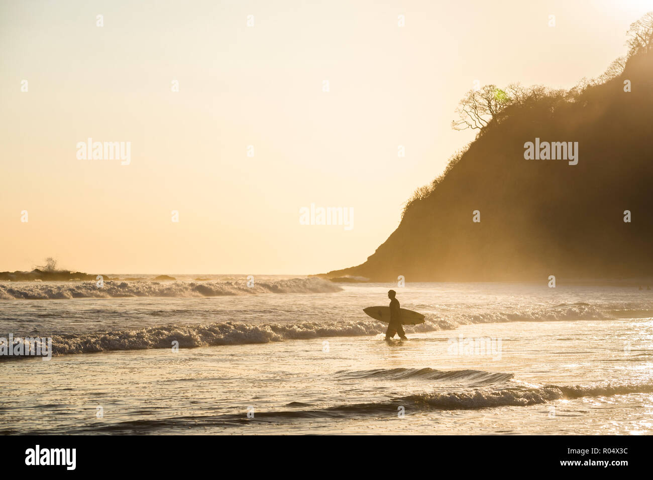 Surfers surf su una spiaggia al tramonto, Nosara, provincia di Guanacaste, Pacific Coast, Costa Rica, America Centrale Foto Stock