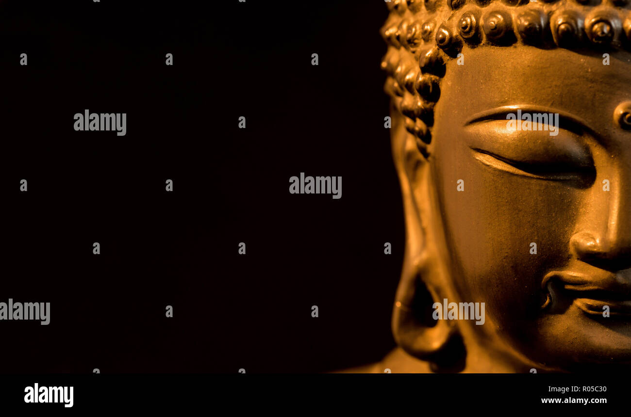 Golden BUDDA STATUETTA in atto di meditare (su sfondo nero con copia spazio) Foto Stock