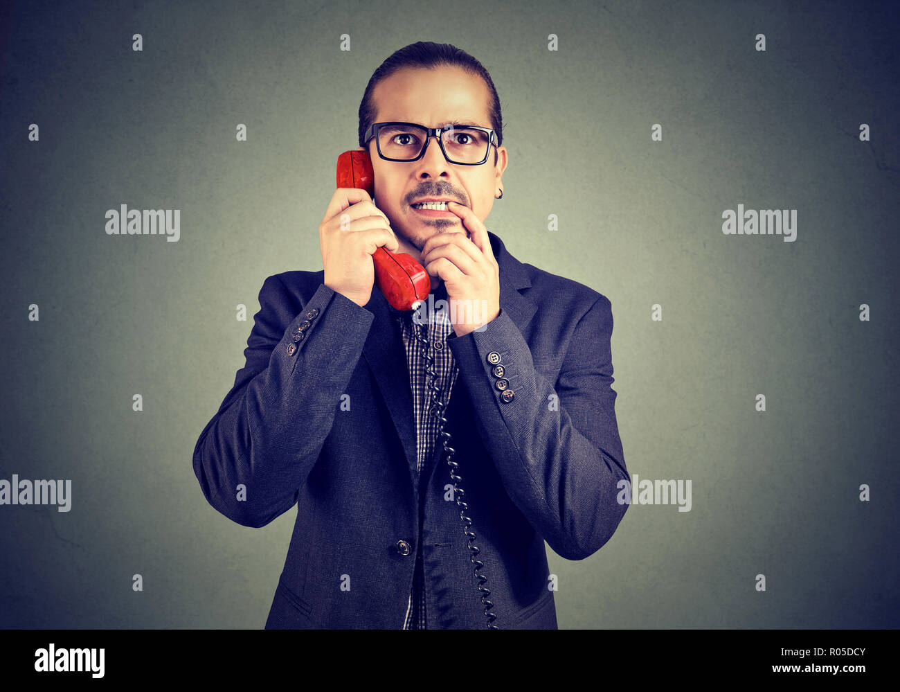 Solleciti l'uomo in bicchieri parlando sul telefono alla ricerca fino a stupito e confusione Foto Stock