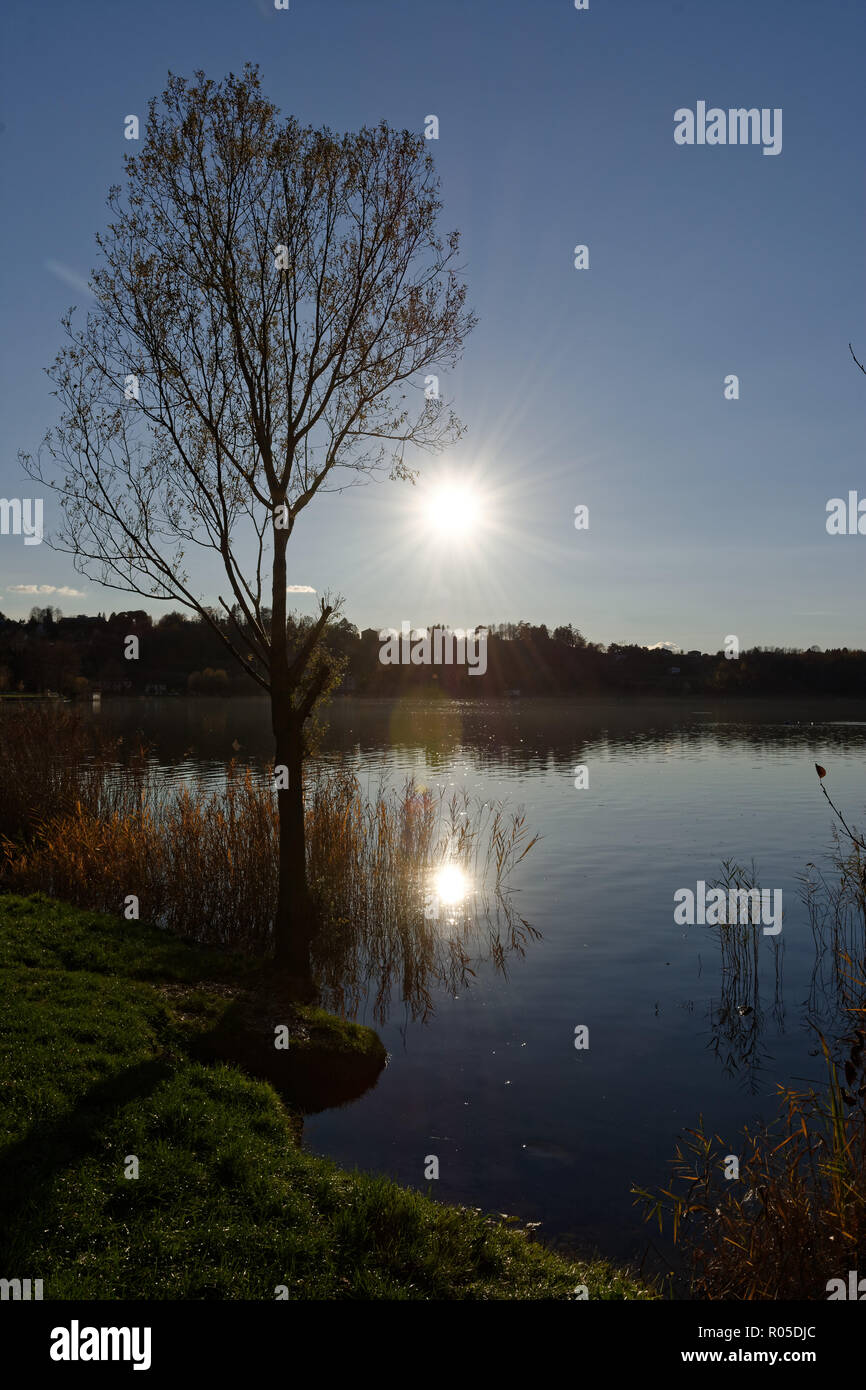 Tramonto sul lago con raggi solari e riflessioni Foto Stock