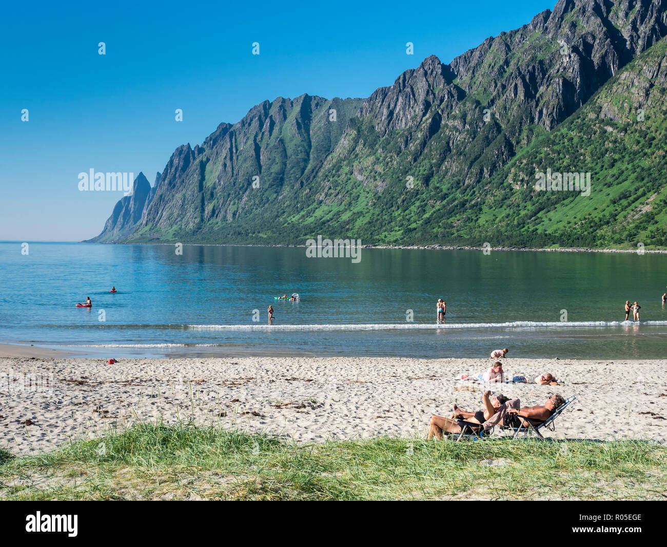 Spiaggia Ersfjordstranden, fjord Ersfjord, pubblica Recreation Area, estate, persone andare a nuotare, vista la gamma della montagna Okshornan, isola Senja, Troms, n Foto Stock