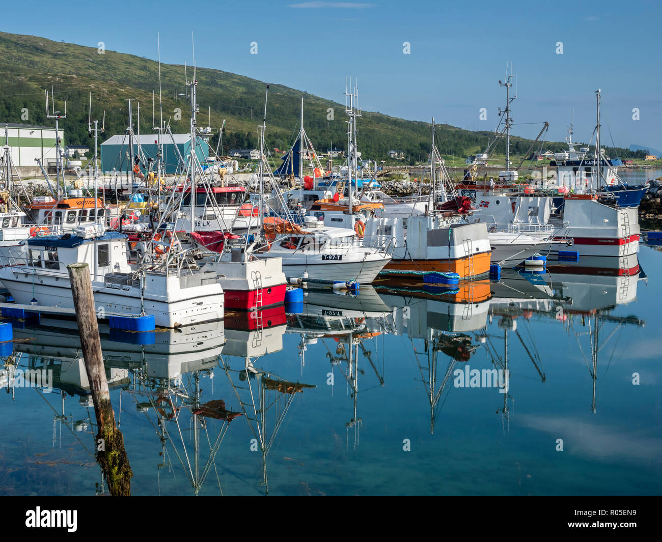 Botnham, porto di traghetto kai, ancoraggio dei pescherecci, calma e soleggiata giornata estiva, riflessioni sul mare calmo, Senja, Troms, Norvegia Foto Stock