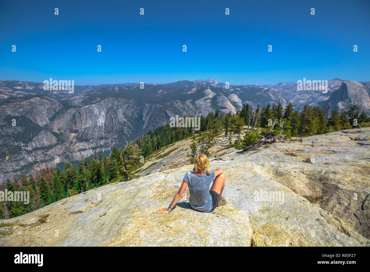 Escursionismo donna seduta rilassante a cupola Sentinel vetta del Parco Nazionale di Yosemite. Felice dopo escursioni e godendo di El Capitan vista in Sentinel Dome. Estate vacanze viaggi in California, Stati Uniti. Foto Stock