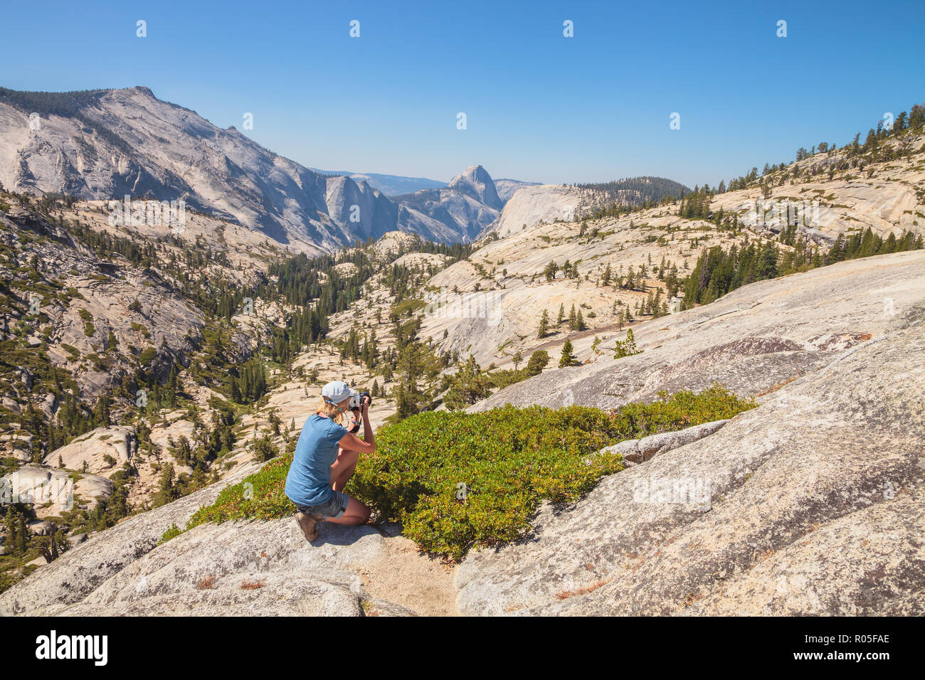 Trekking traveler fotografo riprese la mezza cupola su Olmsted Point. Tioga Road nel Parco Nazionale di Yosemite in California, Stati Uniti d'America. Fotografo di natura a scattare foto all'aperto durante le escursioni in viaggio. Foto Stock