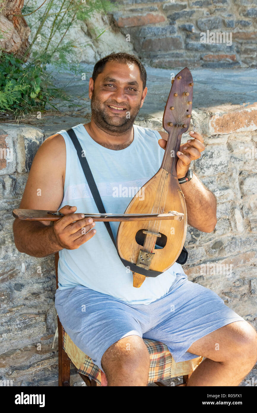Uomo locale giocando cretese strumento lyra, Agios Nikolaos, Λασίθι, Creta (Kriti), Grecia Foto Stock