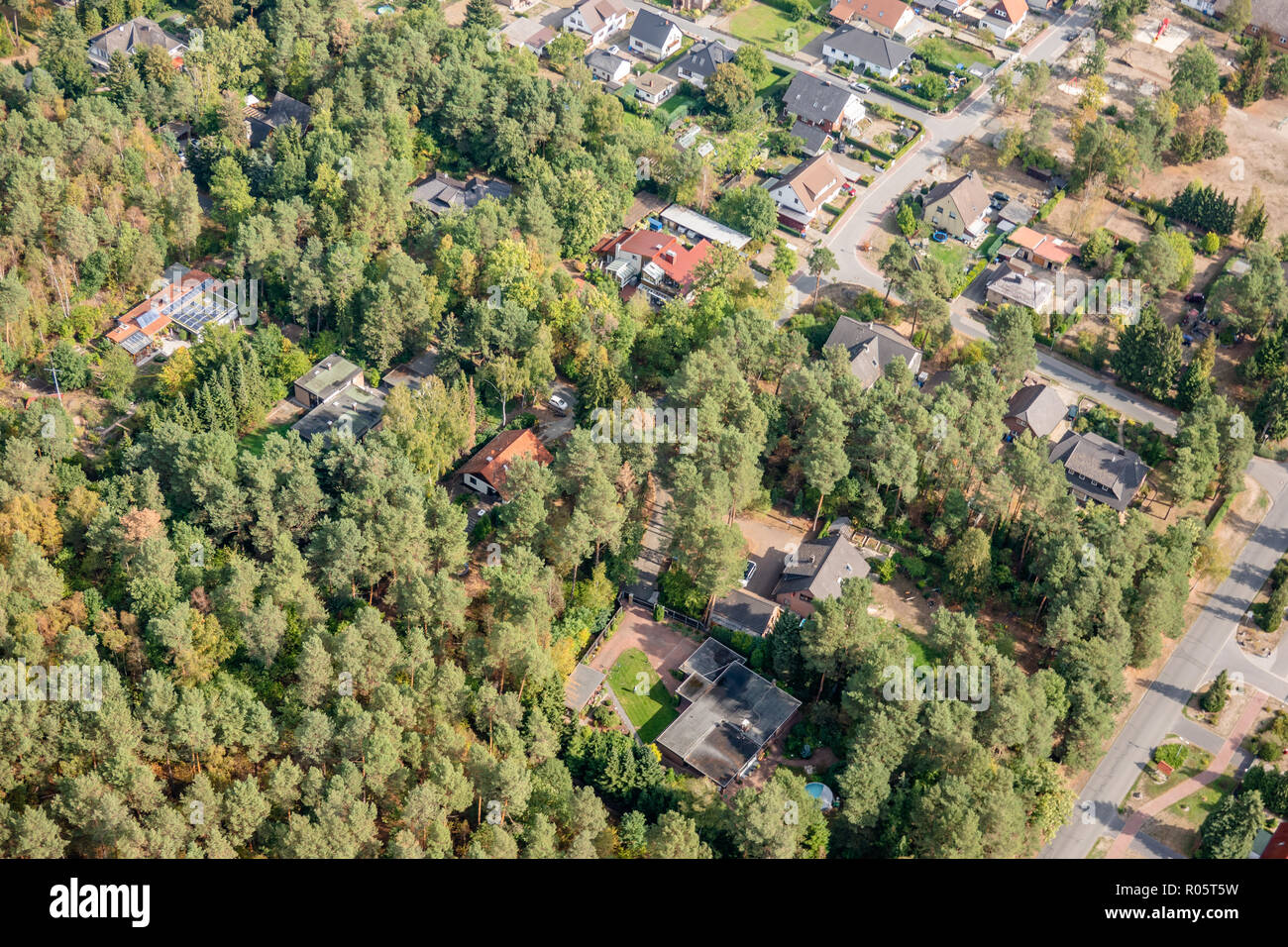 Vista aerea del bordo di un villaggio con piccole case famiglia, le cui proprietà penetrare nella fitta foresta Foto Stock