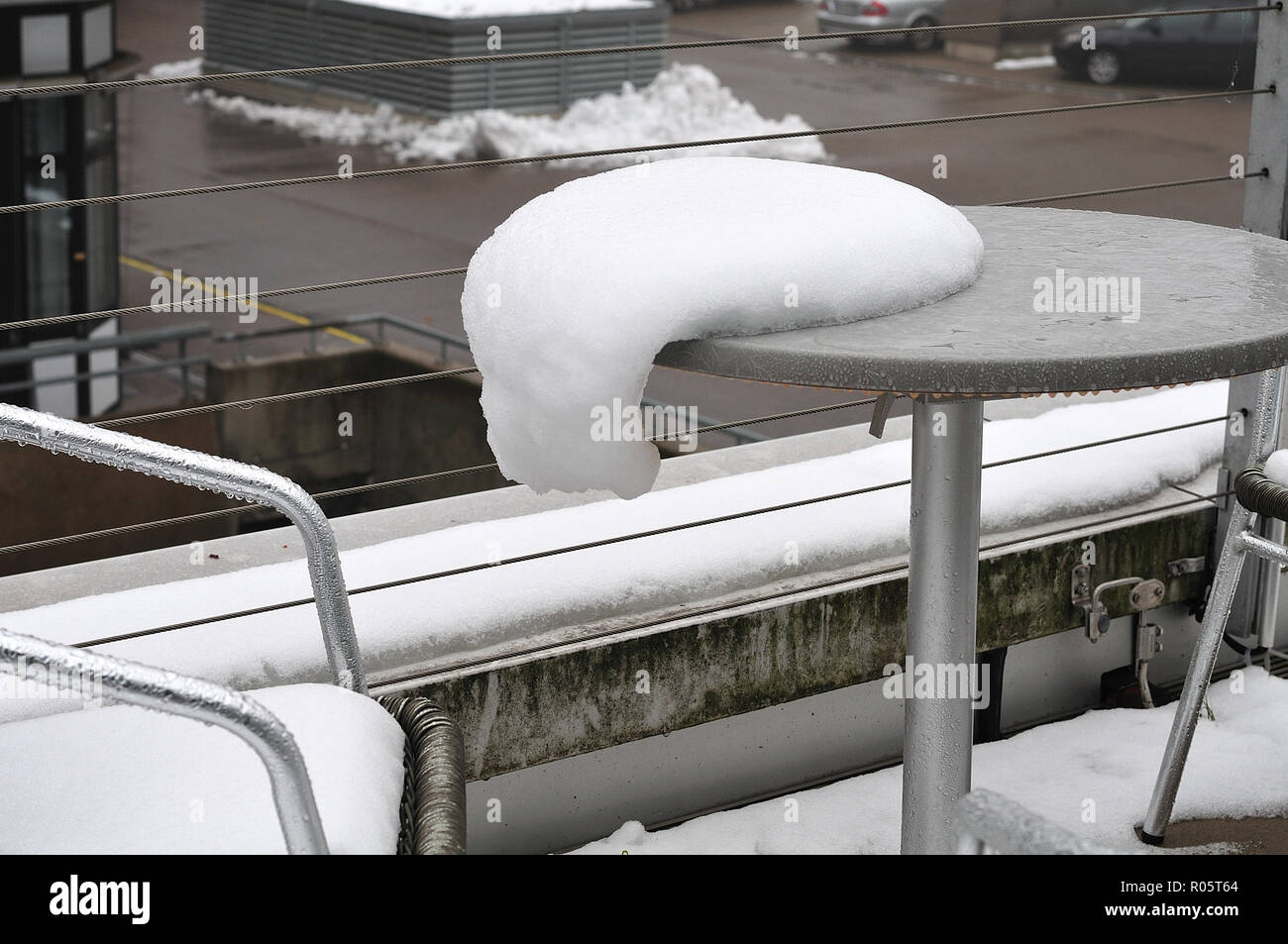 Prima neve dell'anno giacente sul tavolo e sede di un marciapiede cafÃ© in autunno Foto Stock