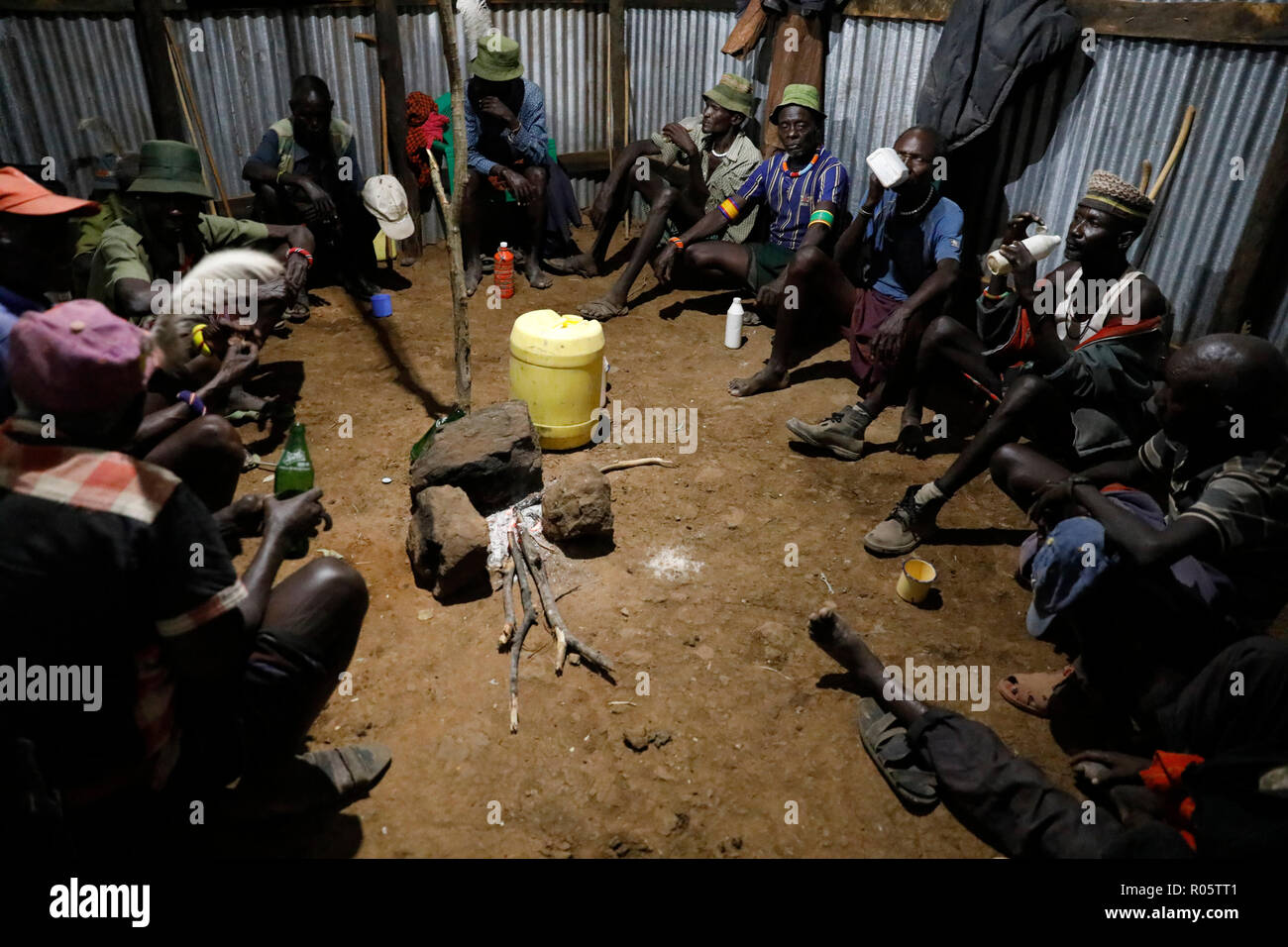 Gli anziani socializzano in una casa mentre bevono una birra fatta in casa all'inizio di una tradizionale cerimonia di iniziazione in Kenya. Foto Stock