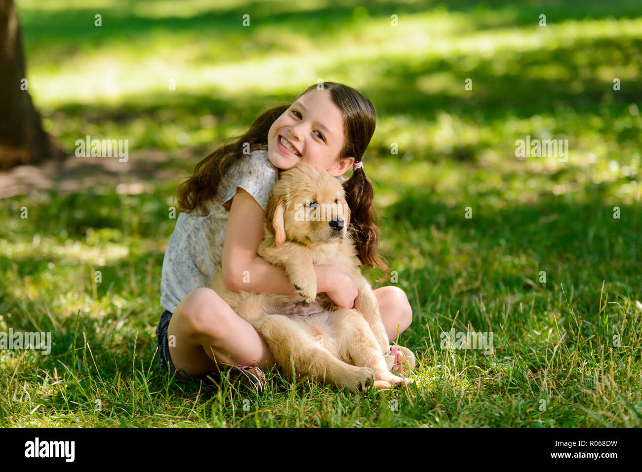 Ragazza gioiosa abbraccia il suo animale domestico Foto Stock