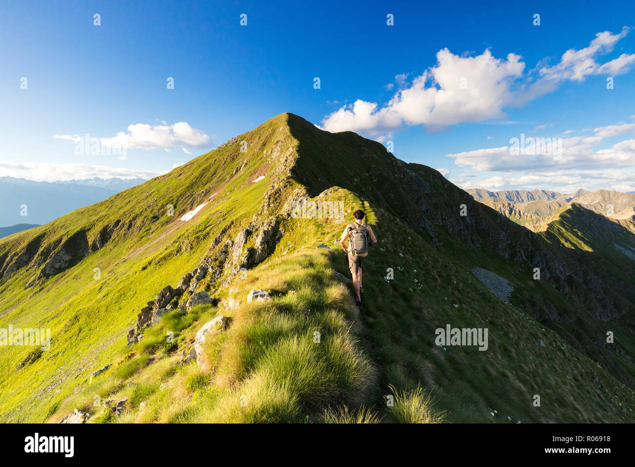 Escursionista sulla ripida cresta su per la salita verso Monte Azzarini, Passo San Marco, Albaredo Valle, Alpi Orobie, Lombardia, Italia, Europa Foto Stock
