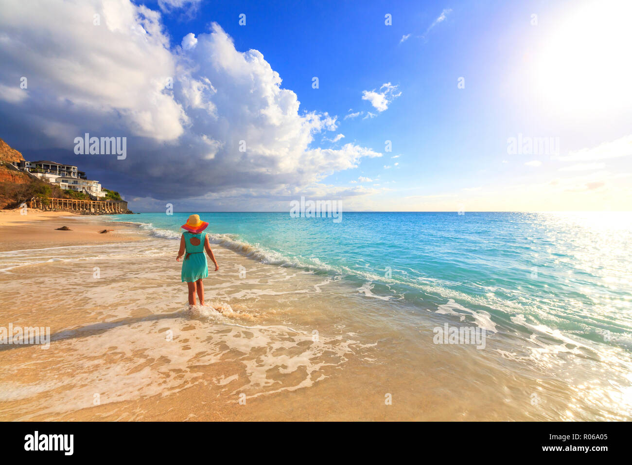 Vista posteriore della donna con cappello camminando sulla spiaggia Ffryes, Antigua Antigua e Barbuda, Isole Sottovento, West Indies, dei Caraibi e America centrale Foto Stock