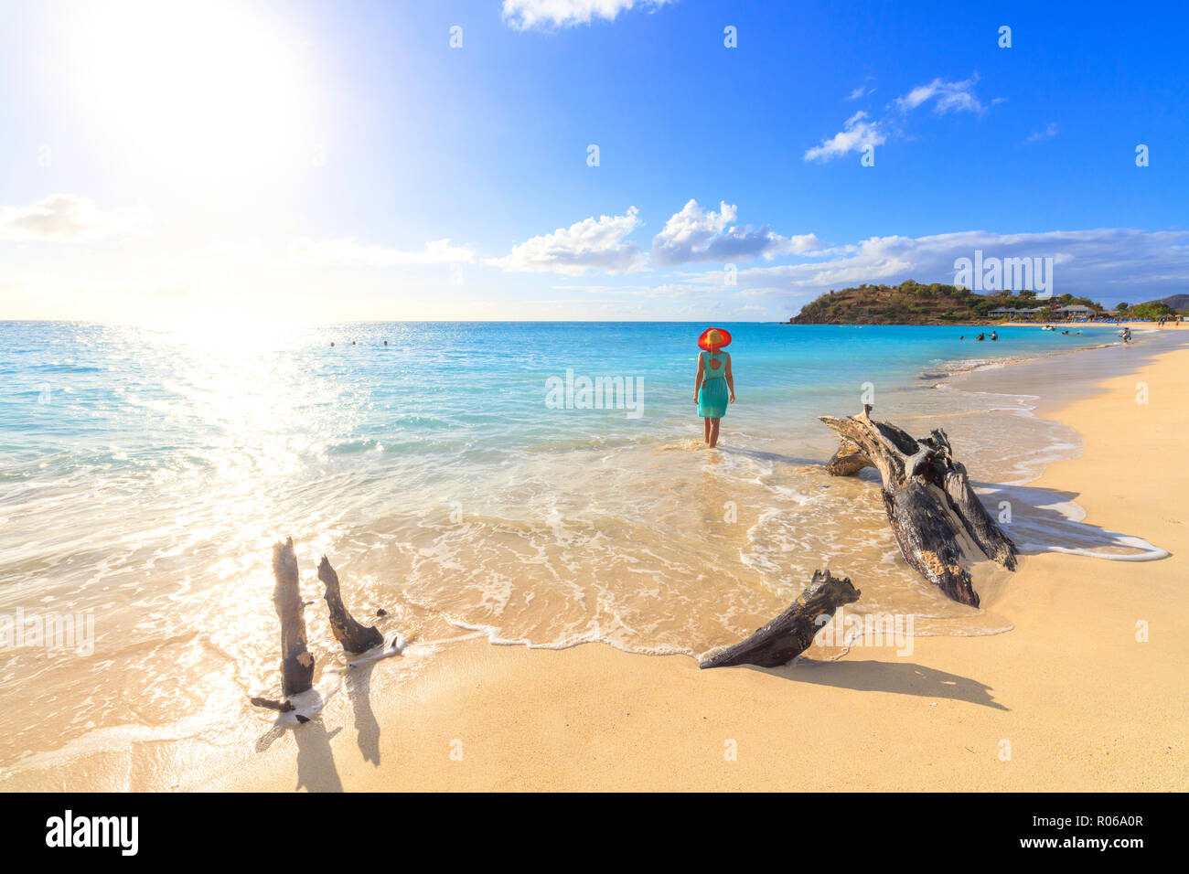Vista posteriore della donna con cappello camminando sulla spiaggia Ffryes, Antigua Antigua e Barbuda, Isole Sottovento, West Indies, dei Caraibi e America centrale Foto Stock