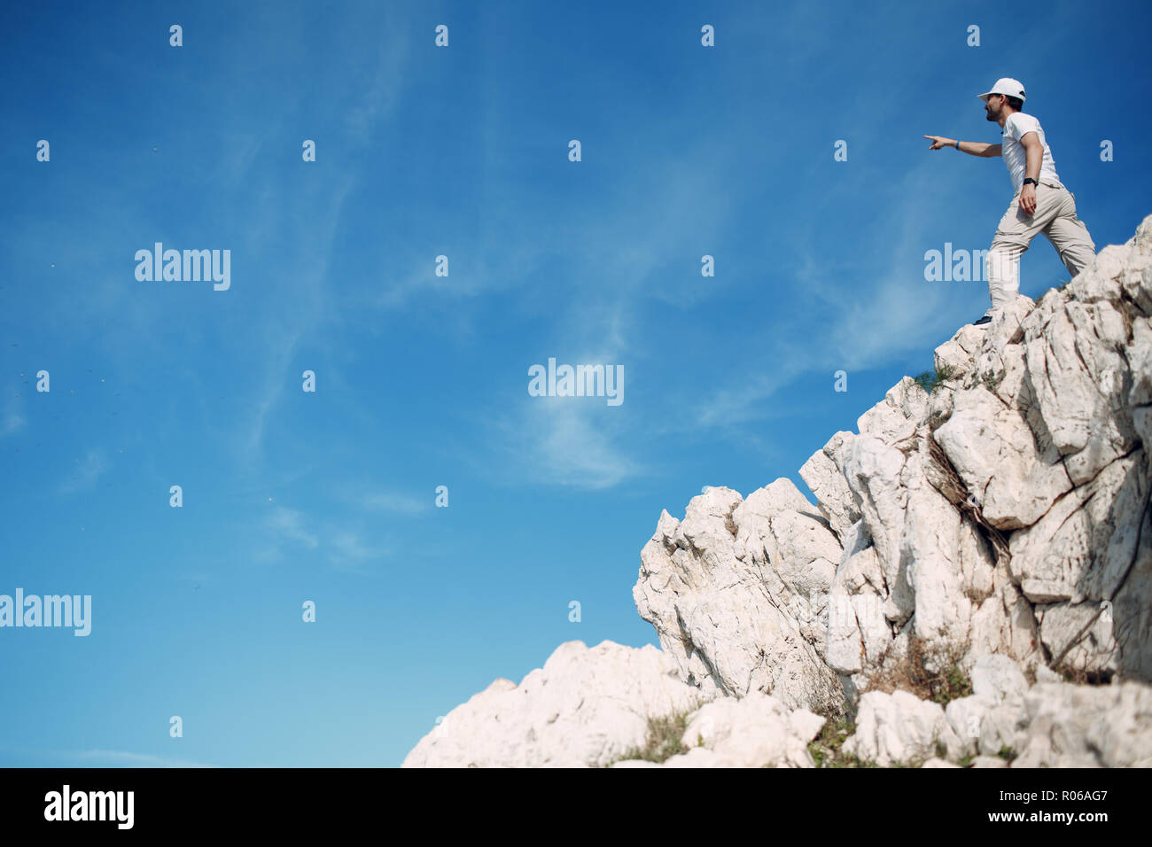Giovane maschio rocciatore in cima a una scogliera Foto Stock