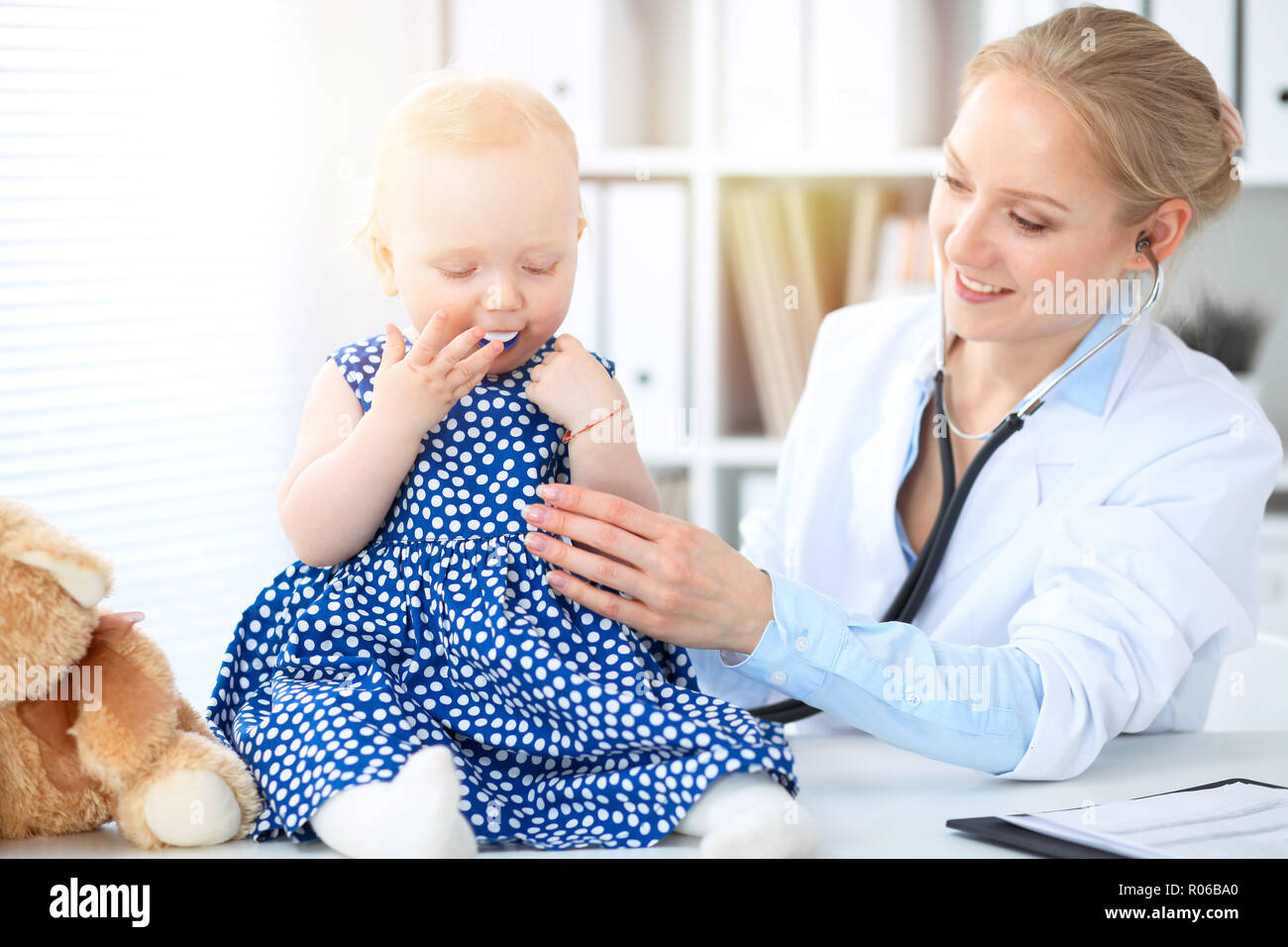 Il medico e il paziente in ospedale. Bambina viene esaminata dal pediatra con stetoscopio. Medicina e salute Foto Stock